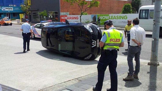 A car sits on its side in Ann Street, Fortitude Valley, after a "slight nudge" from another vehicle.