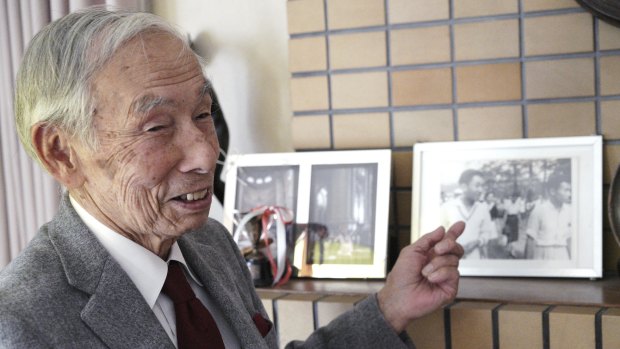 Kazuo Oda, a long-time tennis friend of Emperor Akihito, points to a photograph of him with the then crown price Akihito and Michiko Shoda, who became Empress.