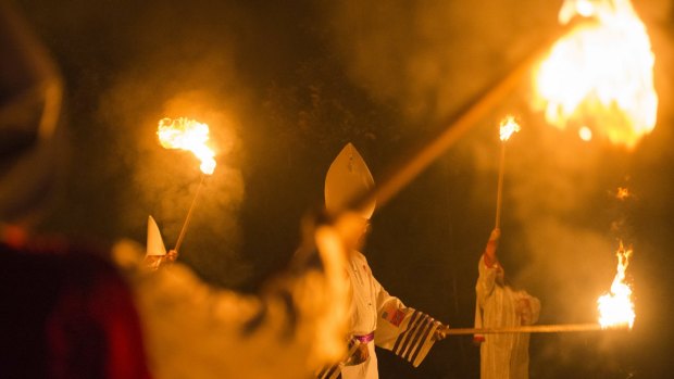 Members of the Rebel Brigade Knights and the Nordic Order Knights, groups that both claim affiliation with the Ku Klux Klan, hold their lit torches during a cross lighting ceremony at a private residence in Virginia in 2014.