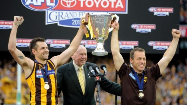 The 2013 premiership coach, at right, with club legend John Kennedy and Hawks captain Luke Hodge.