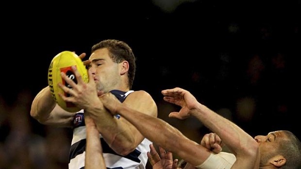 It's mine: Geelong's Trent West leaps to take a screamer against the Hawks last night.