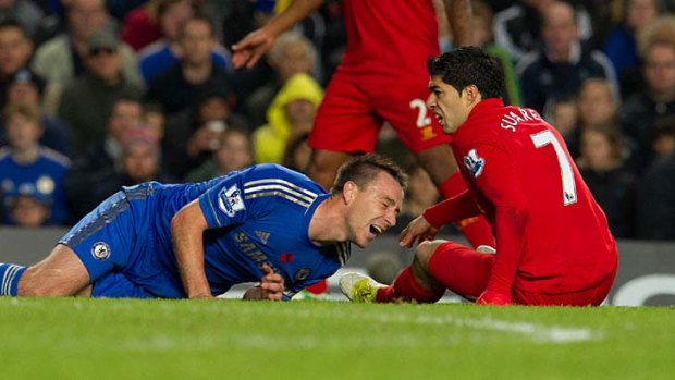 Chelsea's John Terry lies on the pitch after a tackle from Liverpool's Luis Suarez.