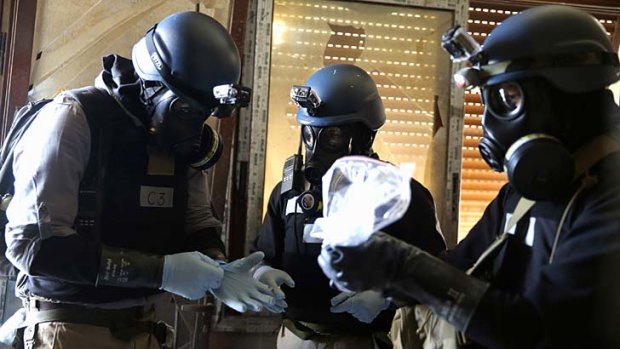 A UN chemical weapons expert holds a plastic bag containing samples from one of the sites of an alleged chemical weapons attack in the Ain Tarma neighbourhood of Damascus.