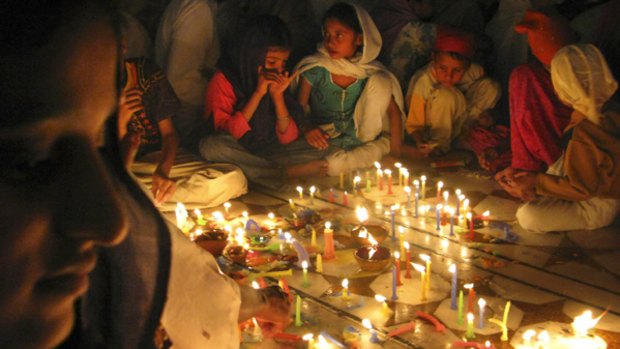 Indian women light candles for the festival of Diwali.