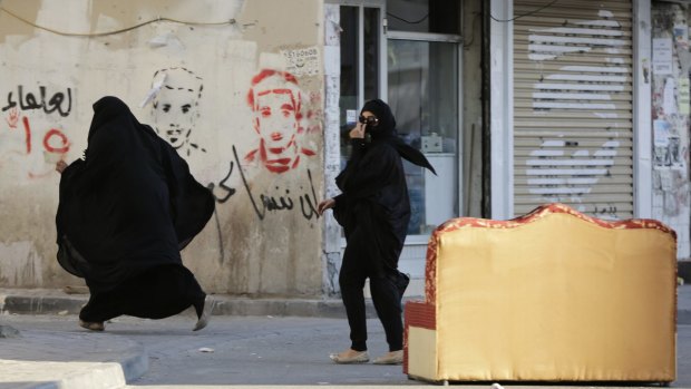 Bahraini women run from approaching riot police during protests in the Bahraini capital Manama in January 2016.