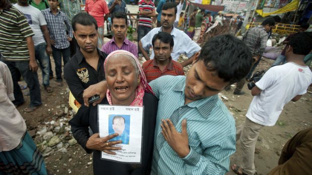 A Bangladeshi woman cries while holding a picture of her son Asadul, who went missing in the Rana Plaza building collapse, as she participates in a protest in Dhaka, Bangladesh.