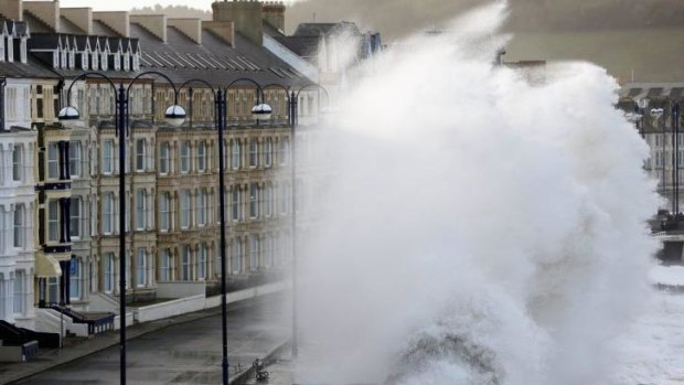 Waves crash up against the sea defences at the Welsh town of Aberystwyth during high tide and high winds.