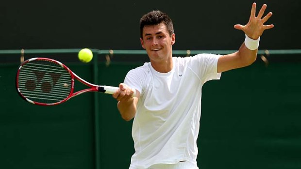 Bernard Tomic plays a forehand during his first-round match against Sam Querry.