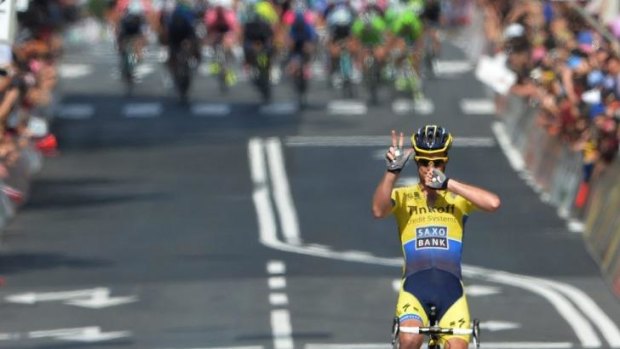 Michael Rogers of Australia claims the stage victory as the peloton looms behind him.