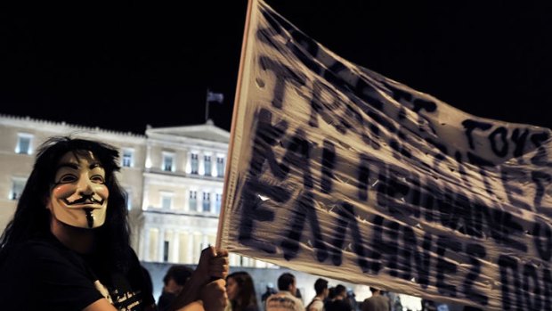 A masked demonstrator protests in front of the Greek parliament against new austerity measures.