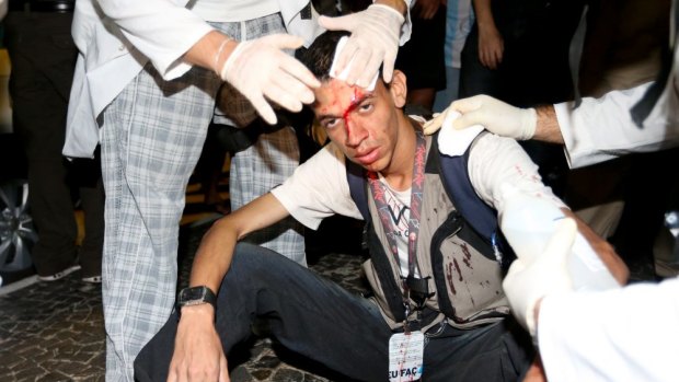Medics help a person injured during an anti-World Cup protest during their march on Copacabana beach on June 12.