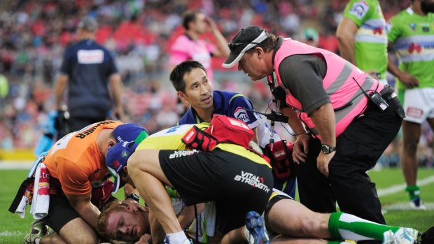 Raiders doctor Wilson Lo, centre, checks Joel Edwards after he was concussed against the Panthers.