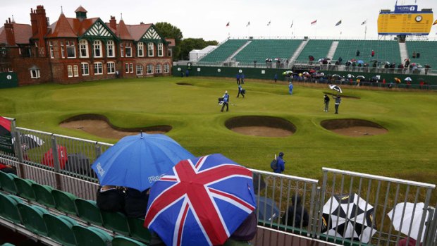 Weather watch: Umbrellas at the ready, fans watch practice rounds on the 18th.