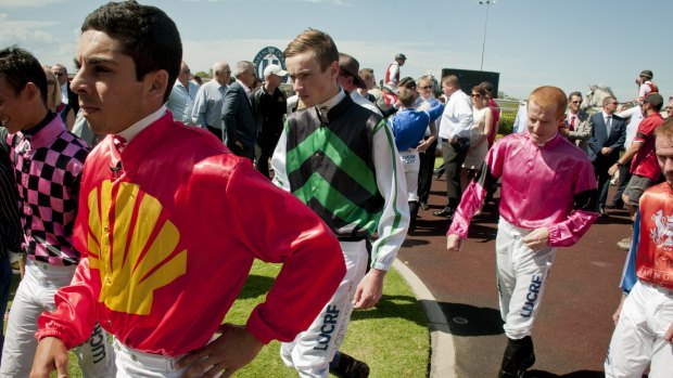Jockeys gather at the winners area at Doomben racecourse to pay their tributes to Tim Bell with one minute silence.