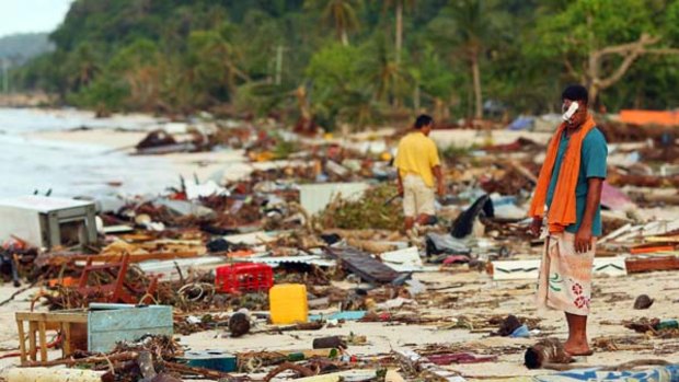 Scene of devastation ... Lalomanu residents walk on the beach after the tsunami.
