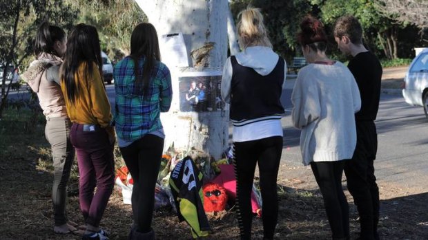Scene of this morning's fatal accident on Eggleston Crescent, Chifley. School friends from Stromlo High, gather at the tree where the car hit.