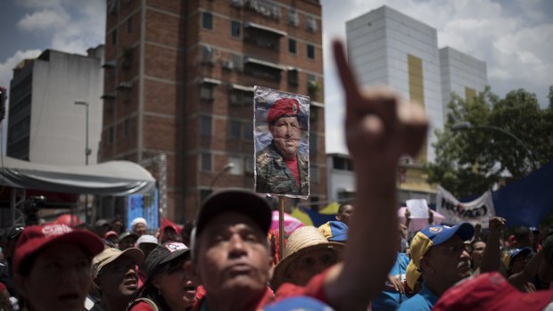 Government supporters hold signs of the late Venezuelan President Hugo Chavez during a rally in Caracas on Tuesday.