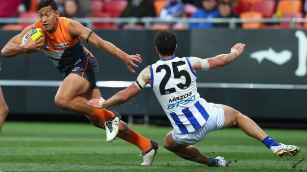 Playing against the Kangaroos: Folau evades a North Melbourne opponent while playing for GWS Giants in 2012.