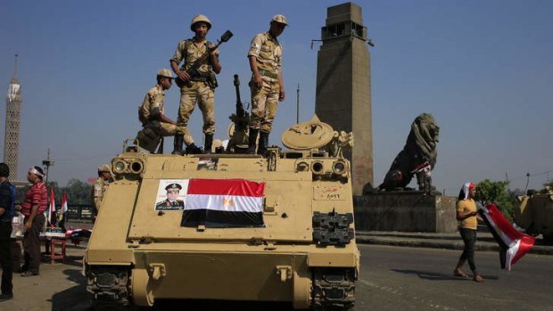 Lockdown: Egyptian soldiers stand guard atop an armoured personnel vehicle on a bridge that leads to Tahrir Square in Cairo.