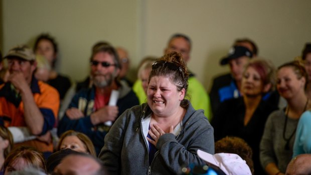 An emotional woman inquires about the status of her house and pets at a community meeting in Lancefield.