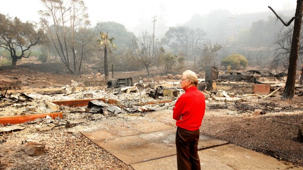 Mike Rippey looks over the burnt out remains of his parents home  on Tuesday.