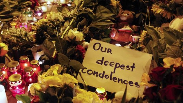 A message of condolence is left among candles and flowers near the Dutch embassy for victims of MH17.