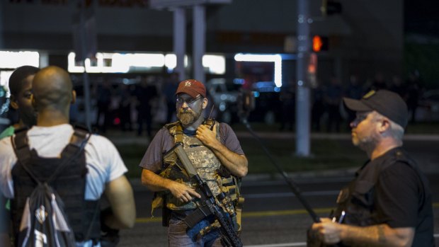 Members of the Oath Keepers patriot group patrol the streets of Ferguson after police in riot gear clashed with protesters on Sunday and Monday nights.