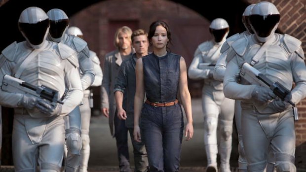 Katniss (Jennifer Lawrence) being escorted to a second round of Hunger Games in <i>Catching Fire</i>.