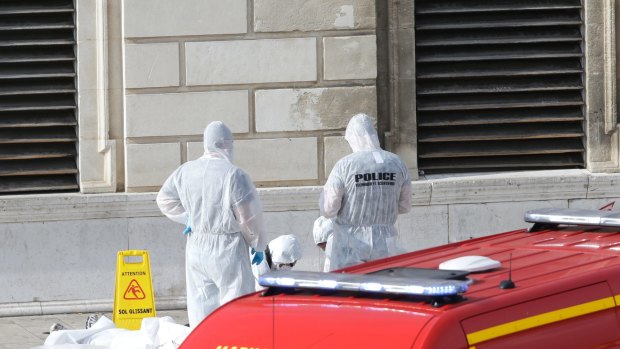 Investigative police officers work at a body outside Marseille 's main train station.