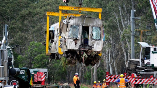 Cranes remove one of the carriages from the train crash site near the Abbotts Road level crossing in Dandenong South.