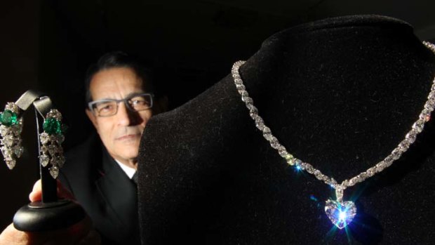 Glimmer of hope ... Sotheby's head of jewellery, Hamish Sharma, with a pair of Bulgari diamond and emerald earrings and a 24-carat diamond necklace.