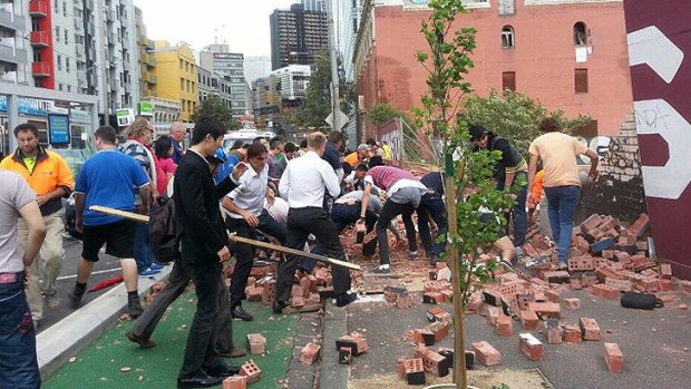 People rush to the scene of the wall collapse.