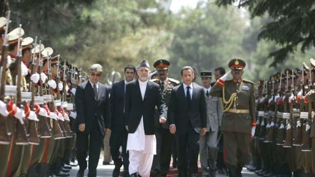 Unwavering: Afghan President Hamid Karzai (left) and French President Nicolas Sarkozy walk through a guard of honour in Kabul yesterday. PICTURE: AP
