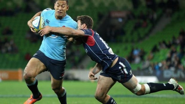 Israel Folau of the Waratahs breaks a tackle on his way to scoring.