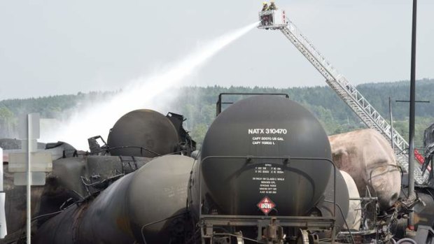 "Like a war zone": Firefighters continue hosing down freight wagons a day after a runaway train derailed, causing massive explosions.
