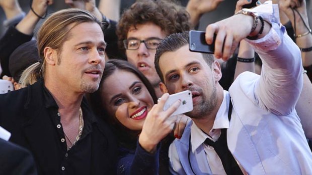 Man of the people: Brad Pitt poses with fans at the Star.