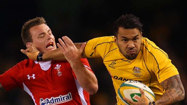 Wallabies winger Digby Ioane brushes aside a would-be Welsh tackler.