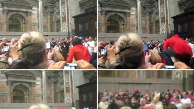 This sequence of images taken from amateur video obtained by APTN shows an unidentified woman jumping over a barrier and grabbing Pope Benedict XVI as a guard pulls her down, while the pope walks down the main aisle to begin Christmas Eve Mass in St Peter's Basilica.