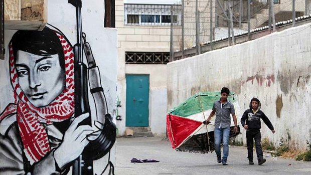 Children carry a hand-made kite painted in the colours of the Palestinian flag at their refugee camp.