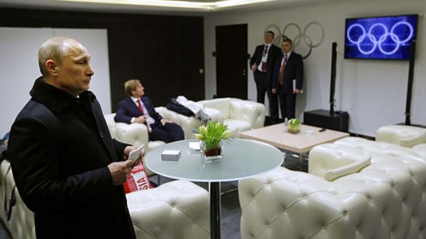 Snow-fake ....  Russian president Vladimir Putin watches footage of the ceremony showing five 'complete' Olympic rings.