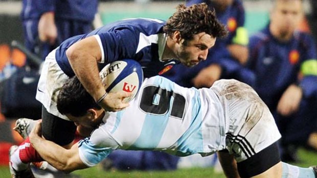 France's wing Marc Andreu is tackled by Argentina's scrumhalf Nicolas Vergallo.