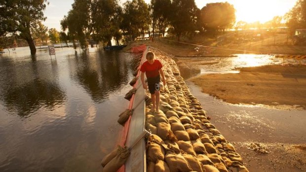 Ethan Low, 11, takes a walk on the 3500 sandbags used to reinforce the levee bank in the middle of the night on the northern outskirts of Nathalia.