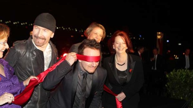 U2 singer Bono, cofounder of One and RED with group member left The Edge, and NSW Premier Kristina Keneally, and Australian Prime Minister Julia Gillard.