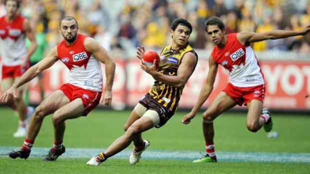 Hawthorn's Cyril Rioli weaves through Sydney's Rhyce Shaw and Lewis Jetta at the MCG yesterday.