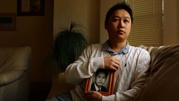 A worried Tommy Du holds a picture of his father, jailed in China.