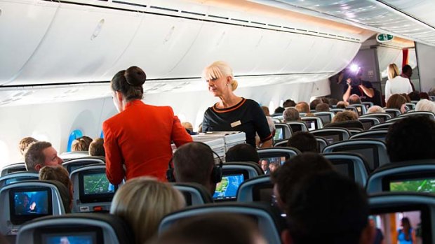 Flight attendants serve passengers on board Jetstar's first commercial Dreamliner flight.