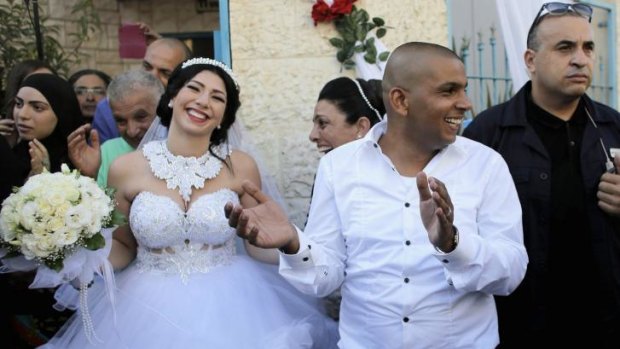 Mahmoud Mansour, 26, and his bride Morel Malka, 23, celebrate with friends, family (and security) before their wedding in Mahmoud's family house in Jaffa, south of Tel Aviv on Sunday.
