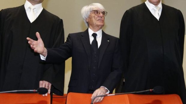 F1 CEO Bernie Ecclestone, centre, stands with his lawyers as he arrives in the  court in Munich, southern Germany, on April 24, 2014. 