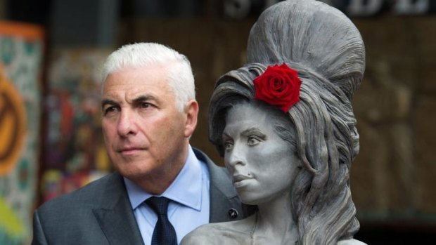 Mitch Winehouse poses for a picture with a statue of his late daughter, Amy Winehouse, in Camden's Stables Market, in London, England.