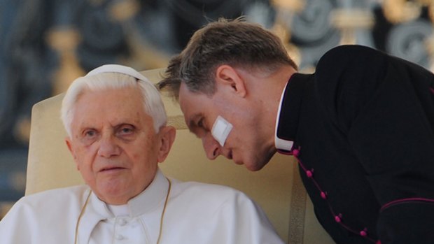 Pope Benedict XVI listens to his personal secretary, Georg Gaenswein.